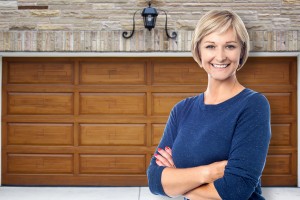 Satisfied homeowner standing in front of newly installed rolling garage doors in Fergus, Ontario