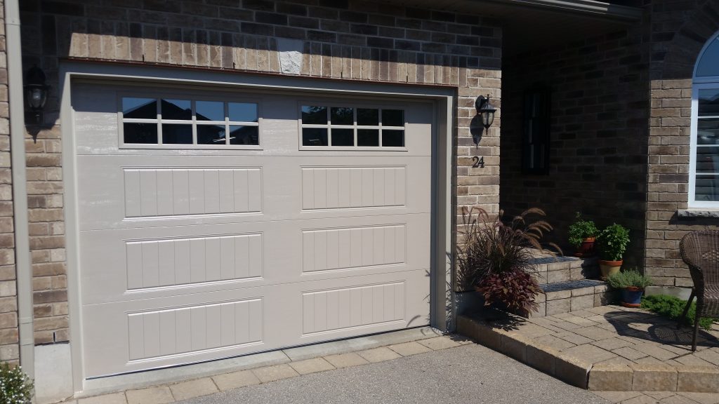 Sandtone Clopay Gallery door with elegant long panel and square 24 window inserts