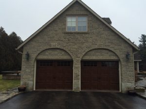 Walnut oak Clopay Gallery short panel door with square grille and strap hardware