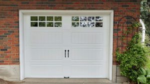 White Clopay Gallery door, elegant long panel with square grille and step plate hardware