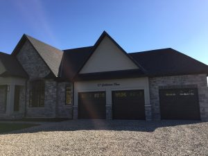 Black Clopay Classic garage door with elegant long panels and arched window inserts