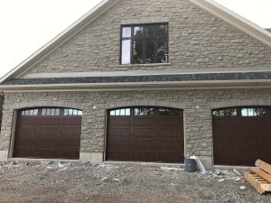 Walnut oak Clopay Gallery 12-foot door with arch-3 and rectangular grille window