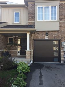 Black Clopay Modern Steel flush door with stucco texture and frosted window inserts