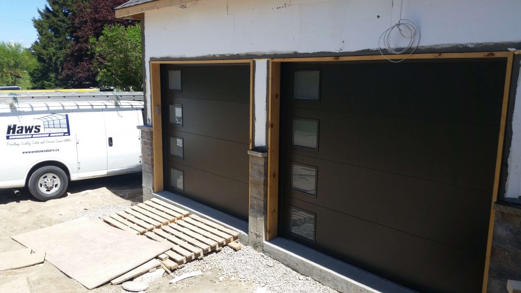 Black Clopay Modern Steel flush panel door with frosted window inserts