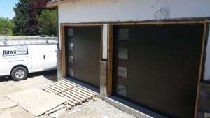Black Clopay Modern Steel flush panel door with frosted window inserts