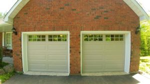 Sandtone Clopay Classic door with elegant short-long panel and square grille window