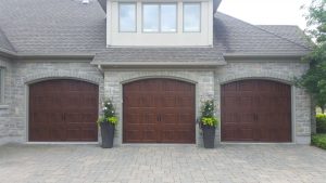 Walnut oak Clopay Gallery door with elegant short panel and decorative step plate hardware