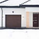 The exterior of a modern, white detached house on a snowy day.