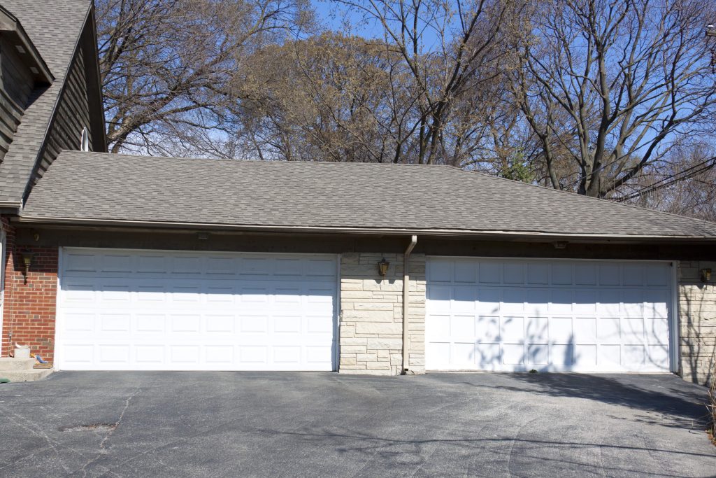 Two white residential garage doors installed side by side on a Guelph-area home