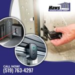 Hand adjusting a garage door safety sensor near the floor track, accompanied by circular insets showing an infrared safety beam and an overhead smart garage camera sensor.